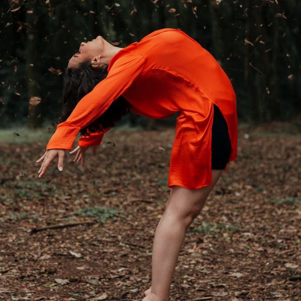 Person stretching outdoors during sunrise, symbolizing well-being and energy.